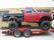 1994 Ford F-250 - Lifted 1994 Ford F-250 pickup truck with a red cab and black bed is loaded onto a trailer.
