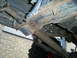 1994 Ford F-250 - The undercarriage of a truck reveals significant rust on the frame and suspension parts.
