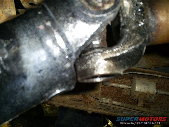 Close-up of a driveshaft U-joint with visible grease and rust