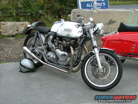Chrome motorcycle with a silver helmet on the ground next to it
