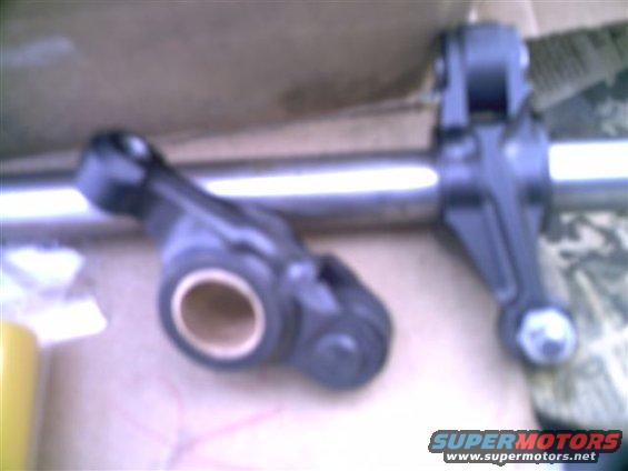 Two engine valve train rocker arms on a metal shaft