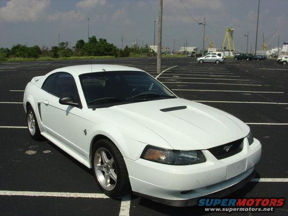 White 1999 Ford Mustang coupe parked in an empty lot