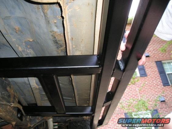 close-up of black metal rock sliders attached to the underside of a vehicle