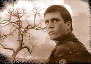 Man in leather jacket with dead tree in background