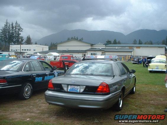 Gray police car, rear view, with light bar and license plate 826WSP