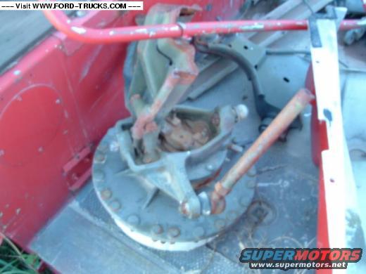 Close-up of a vehicle's suspension assembly with red painted metal components