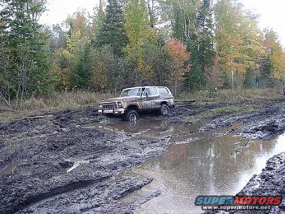 Brown 1978 Ford Bronco stuck in mud, front 3/4 view
