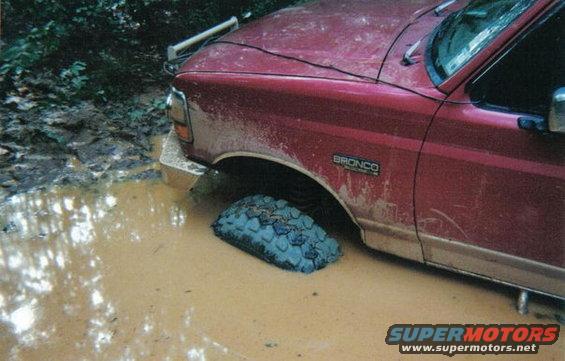 1995 Ford Bronco stuck in deep mud, front passenger side tire submerged