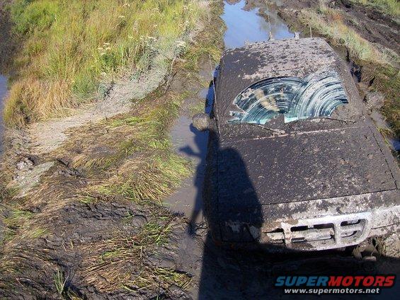 Mud-covered SUV stuck in mud, front view