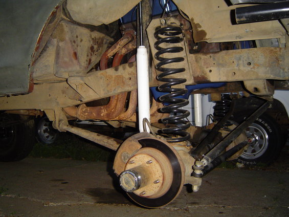 1978 Ford Bronco front suspension with lifted coil springs and rusty exhaust manifold