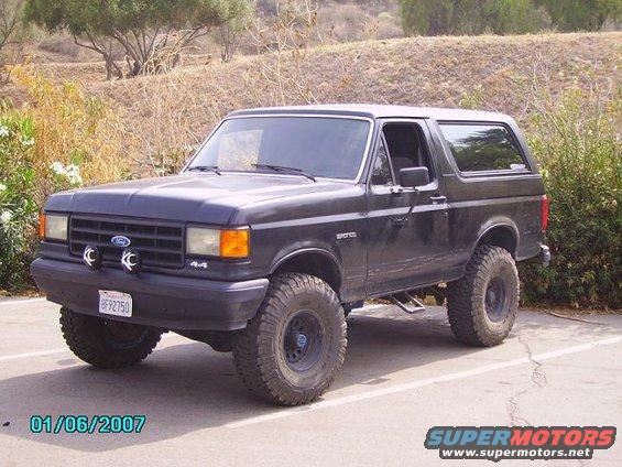 Dark Ford Bronco with off-road tires parked outside