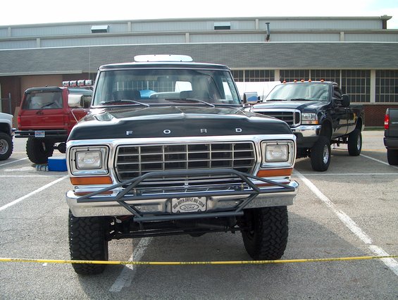 1978 Ford Bronco front view with aftermarket bumper and grille. Other trucks visible in background