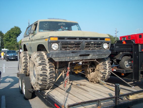 1978 Ford Bronco with massive tires on a trailer, front view