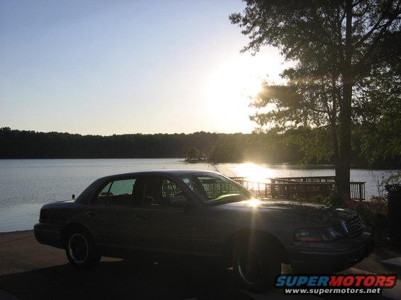 Dark 2000 Ford Crown Victoria parked by a lake at sunset