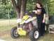 2001 Polaris TRAIL BLAZER - A young woman poses next to a yellow and white all-terrain vehicle.