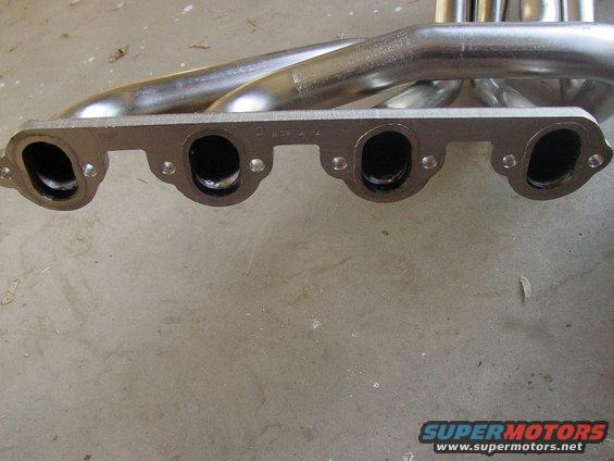 Exhaust manifold with four ports, some stamped text visible