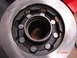 1989 Ford Bronco - Close-up of a brake rotor and hub assembly, with visible lug nuts and a central bearing race.