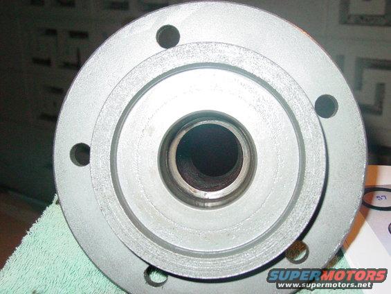 Close-up of a silver metal hub with four bolt holes and a central opening