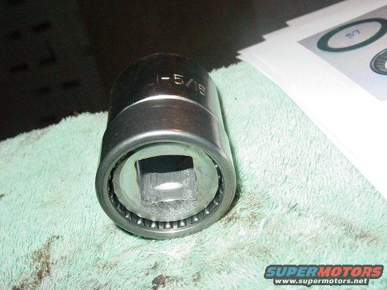 Close-up of a socket wrench part with "1-5/16" etched on it, resting on a green cloth