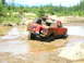 1989 Ford Bronco - Off-road Bronco navigating a muddy trail with a spare tire on the back.