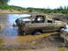 1989 Ford Bronco - A person attempts to free a muddy 1978 Ford Bronco from a deep mud pit.