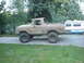 1989 Ford Bronco - This lifted 1978 Ford Bronco features oversized tires and a weathered exterior, parked next to a recreational vehicle.