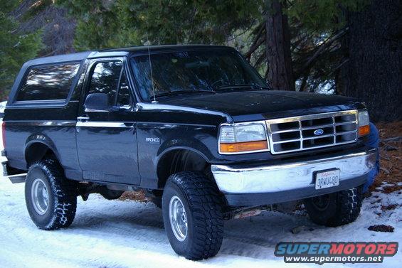 Black 1996 Ford Bronco with lifted suspension parked in snow