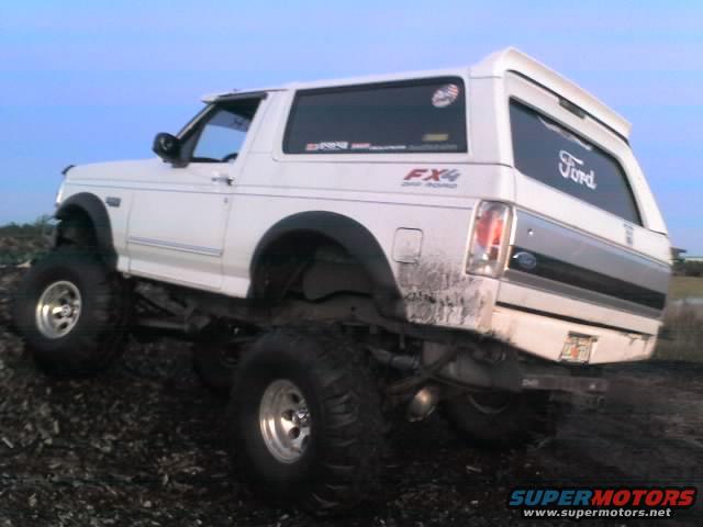 White 1995 Ford Bronco lifted with large tires, rear 3/4 view