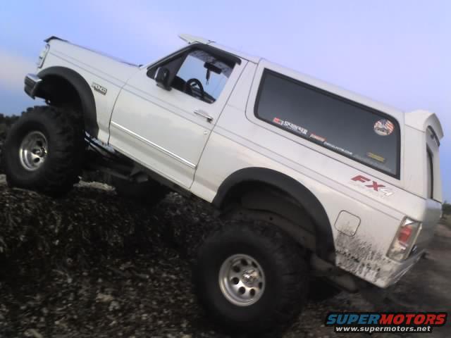 White 1995 Ford Bronco with FX4 badging climbing over rocks