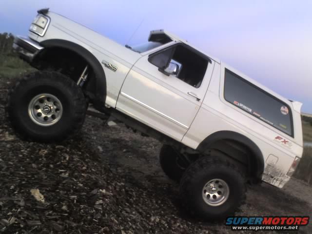 1995 Ford Bronco with large tires on a dirt incline