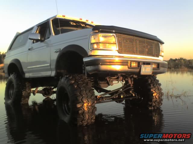 1995 Ford Bronco with large tires partially submerged in water