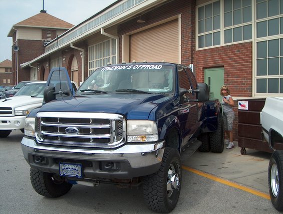 Blue Ford F-350 Super Duty truck with dual rear wheels, front 3/4 view. Chrome grille, aftermarket "FREEMAN'S OFFROAD" decal on windshield
