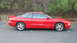 1996 Ford Probe - A red 1996 Ford Probe GT is shown from the side, parked outdoors with trees in the background.