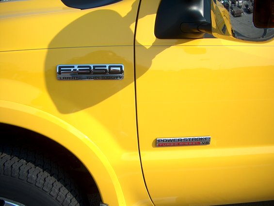 Yellow Ford F-350 Lariat Super Duty truck fender with side mirror and tire visible