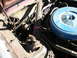 1966 Ford Mustang - The engine bay of a vehicle is shown, with various components and wiring visible under the hood.