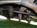 1966 Ford Mustang - Close-up of the undercarriage shows a worn steering component and exhaust system.