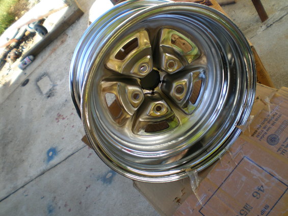 Chrome five-spoke wheel with polished lip, seen from an angle