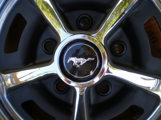 Close-up of a 1966 Ford Mustang wheel with a running horse emblem
