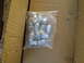 1966 Ford Mustang - A clear plastic bag contains multiple metal lug nuts, sitting within a corrugated cardboard box.
