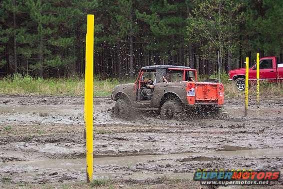 1978 Ford Bronco in mud, rear view. Orange tailgate