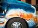 1978 Ford Bronco - Airbrushed artwork of a dragon and mythical figures adorns the side of a truck, with a large chrome wheel in the foreground.