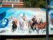 1978 Ford Bronco - A mural on a trailer displays a fantasy scene with dragons, warriors, and wolves.