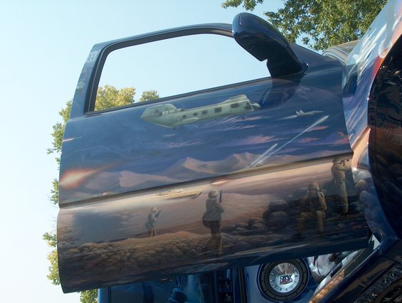 Airbrushed truck door with military scene, showing a helicopter and soldiers