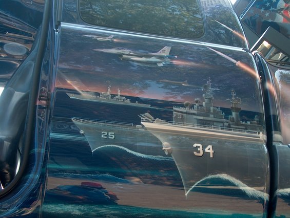 Side of vehicle with air-to-sea battle mural, jets and battleships numbered 25 and 34