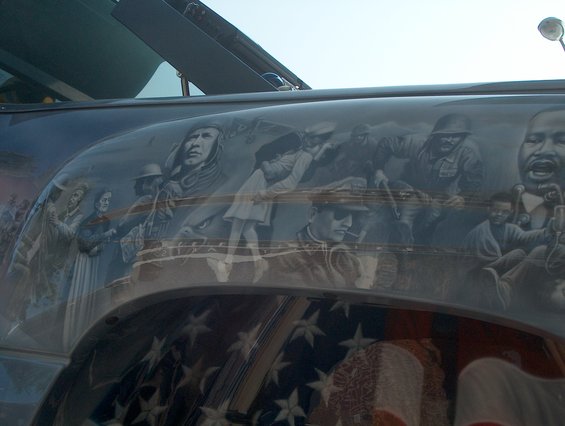 Side of a vehicle with airbrushed mural depicting historical figures and an American flag