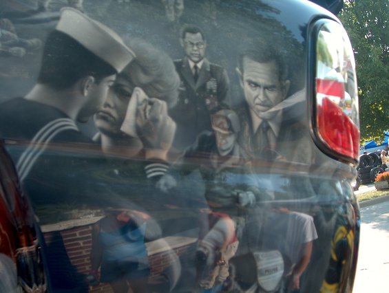 Side view of a vehicle with an airbrushed mural depicting a sailor saying goodbye to a crying woman