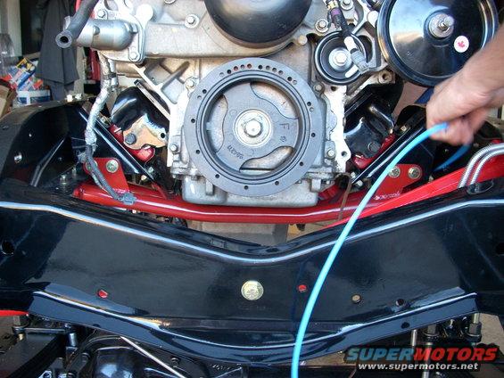 Engine and black chassis parts with red suspension components. A blue wire is visible