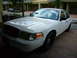 2001 Ford Crown Victoria - A white 2001 Ford Crown Victoria is parked on a brick driveway.