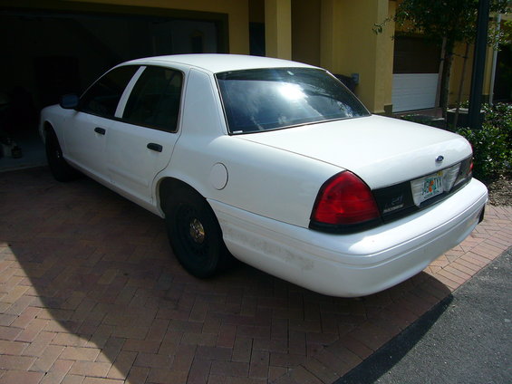 White 2001 Ford Crown Victoria sedan parked on brick driveway, rear quarter view