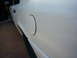 2001 Ford Crown Victoria - The side profile of a white 2001 Ford Crown Victoria, highlighting the fuel door and rear quarter panel.